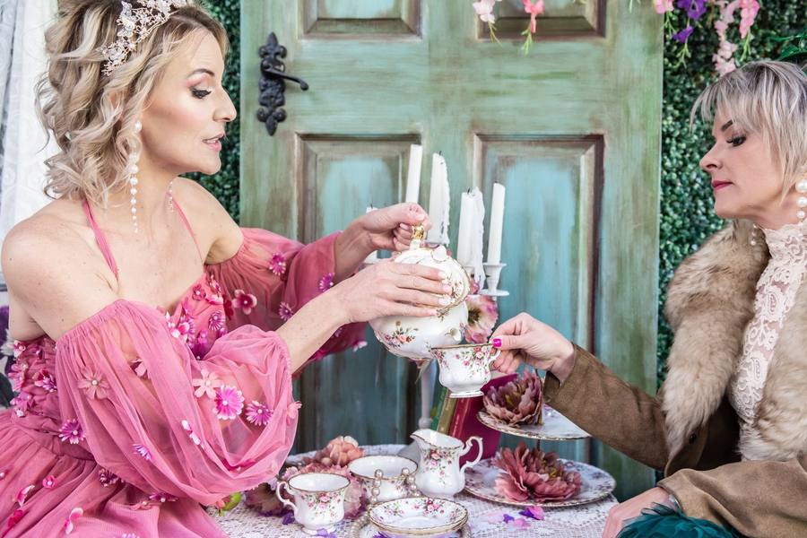 Women in costume pouring tea at Bridgerton High Tea